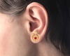 14K gold earrings with floral pattern and a red stone