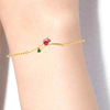 14K gold bracelet with a rose shaped design and a green stone 