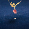 14K gold necklace with double hearts on a stone-studded tulip and a pearl drop 